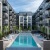 Annapolis, MD Pet-Friendly Luxury Apartments - Aventon Annapolis - Swimming Pool with Lounge Chairs, Greenery, and Apartments Surrounding.